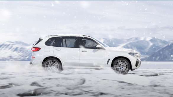 Режим вождения BMW X5 xSnow Режим вождения xSnow BMW X5 G05 2018 Mineral White металик, вид сбоку при движении на снегу