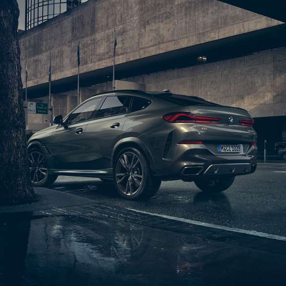 Экстерьер BMW X6. BMW X6, вид сзади с поворотом в три четверти плане перед городской обстановкой.