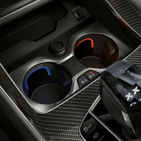 Подстаканник с регулируемой температурой. Крупный план салона BMW с акцентом на подстаканник с регулируемой температурой.