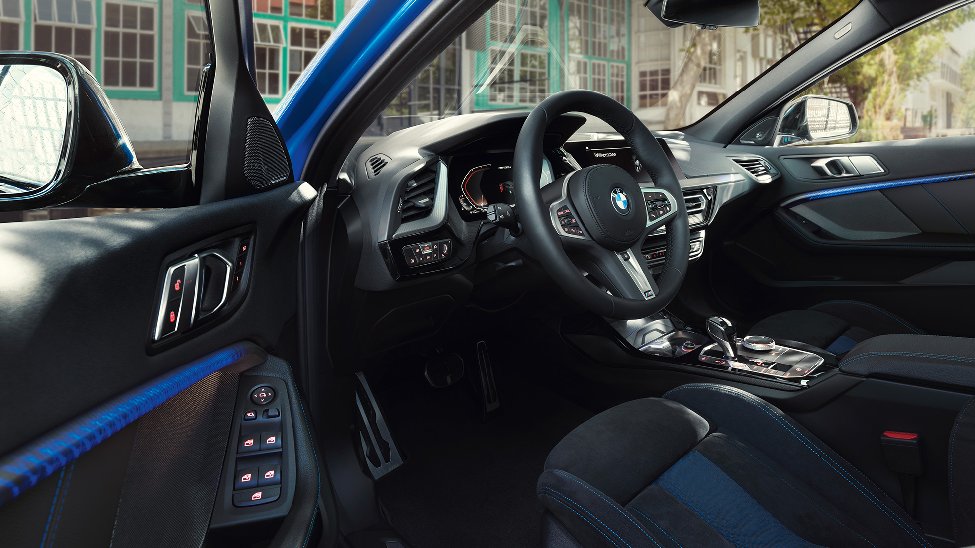 Кабина BMW 1 серии. Кабина BMW 1 серии с кожаным рулевым колесом M при открытой двери водителя.