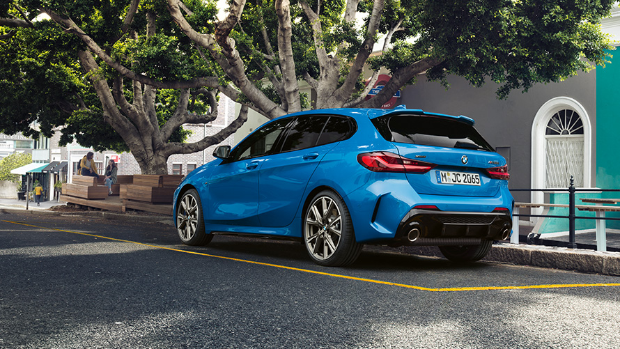 BMW 1-й серии с высоты птичьего полета. BMW 1-й серии в цвете Misano Blue металлик с высоты птичьего полета с человеком на переднем плане.