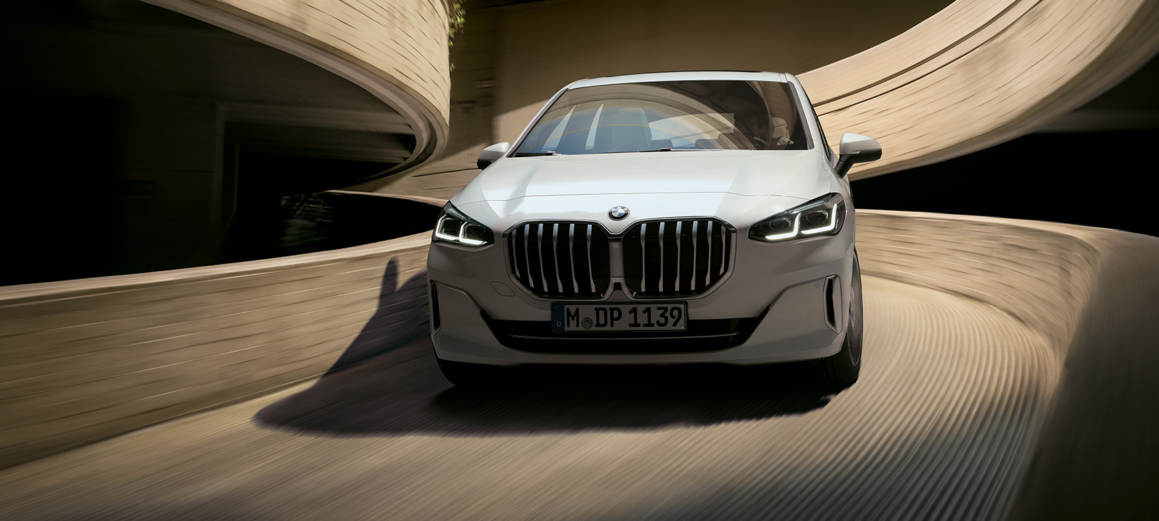 BMW 2 серии Active Tourer U06 2021 в цвете Mineral White металлик, вид спереди в движении на парковке
