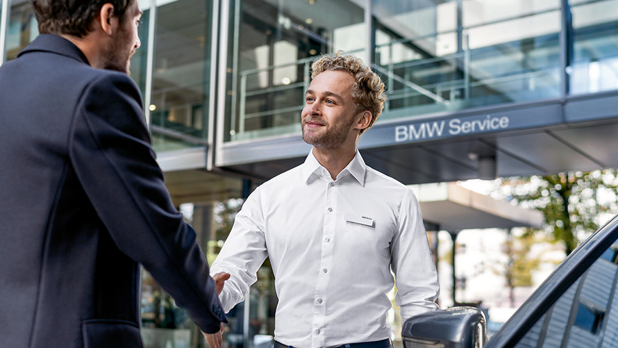 Сотрудник сервисного центра BMW консультирует клиента. Сотрудник сервисного центра BMW консультирует клиента.