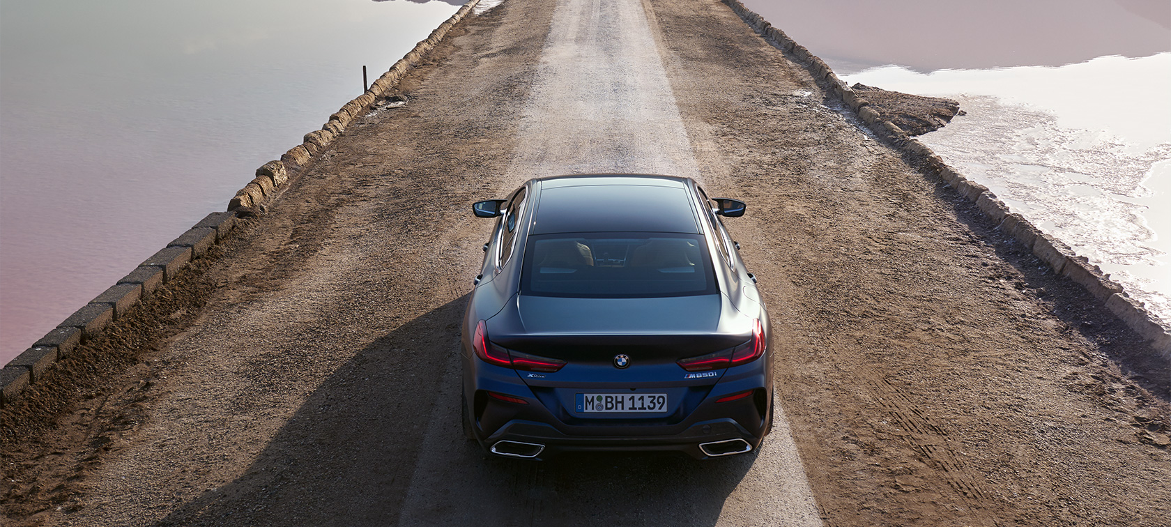BMW M850i xDrive 8 серии Gran Coupé G16 LCI (рестайлинг 2022 года) в эксклюзивном цвете BMW Individual Морозный Синий Танзанит металлик, вид сзади с высоты птичьего полета BMW M850i xDrive 8 серии Gran Coupé G16 LCI (рестайлинг 2022 года) в эксклюзивном цвете BMW Individual Морозный Синий Танзанит металлик, вид сзади с высоты птичьего полета