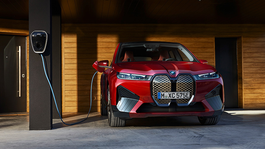 Электрический SUV BMW iX i20 xDrive50 заряжается Электрический SUV BMW iX i20 2021 xDrive50 цвета Aventurin Red заряжается с помощью BMW Wallbox