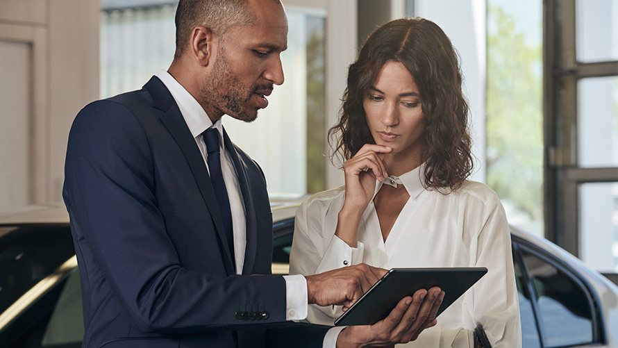 Сотрудник сервисного центра BMW консультирует клиента.