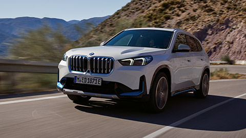 BMW X Series BMW iX1 U11 вид сбоку на дороге