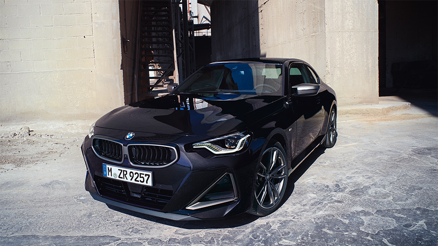 BMW M240i xDrive Coupe G42 2021 &quot;Черный Сапфир металлик&quot;, вид спереди в три четверти в статике перед зданием