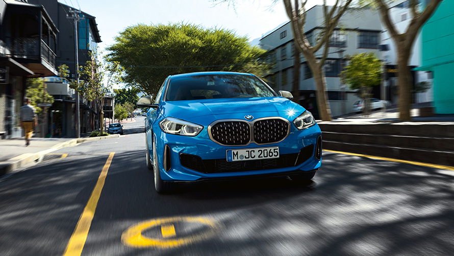 BMW 1 серии вид спереди. BMW 1 серии в Misano Blue металлик, вид спереди за рулем.
