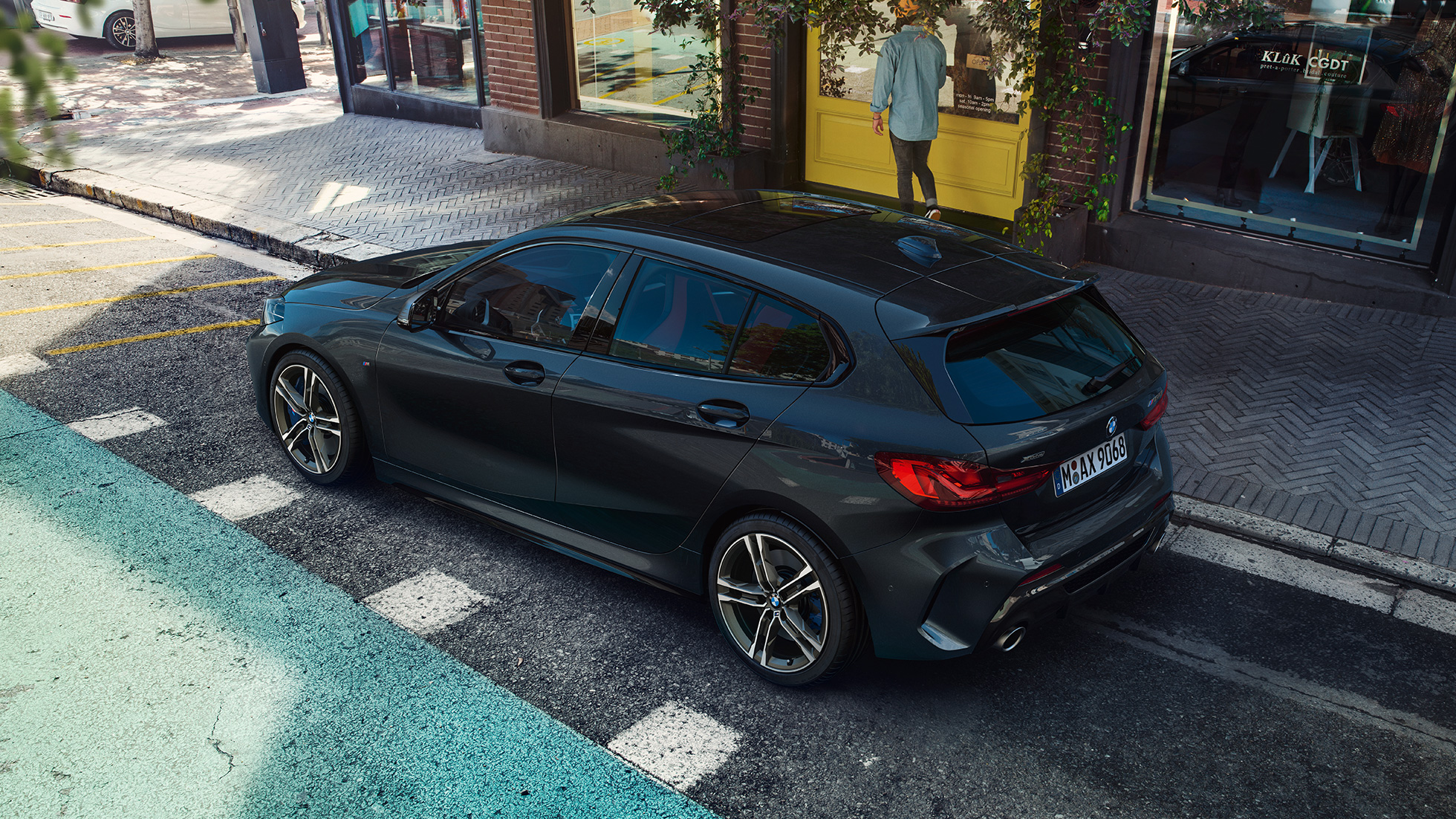 BMW M135i xDrive, парковка. BMW M135i xDrive в Black Sapphire металлик, парковка, вид сбоку с высоты птичьего полета.
