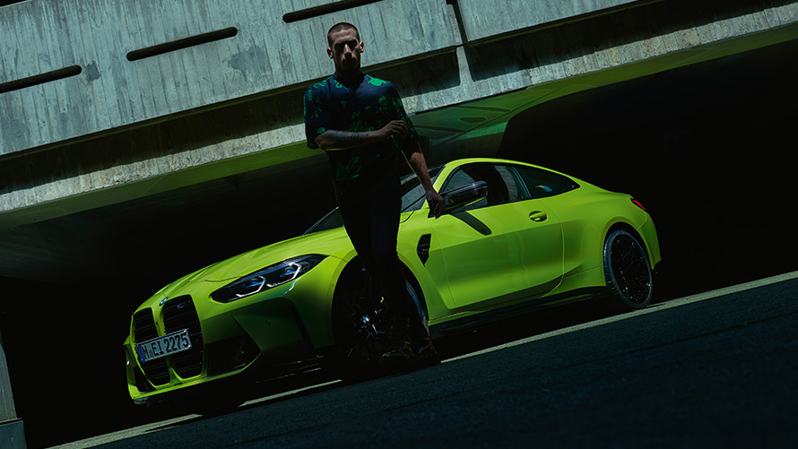 BMW M440i xDrive Coupé G22 2020 вид на передние три четверти с моделью впереди BMW M440i xDrive Coupé G22 2020, вид спереди в три четверти с моделью впереди