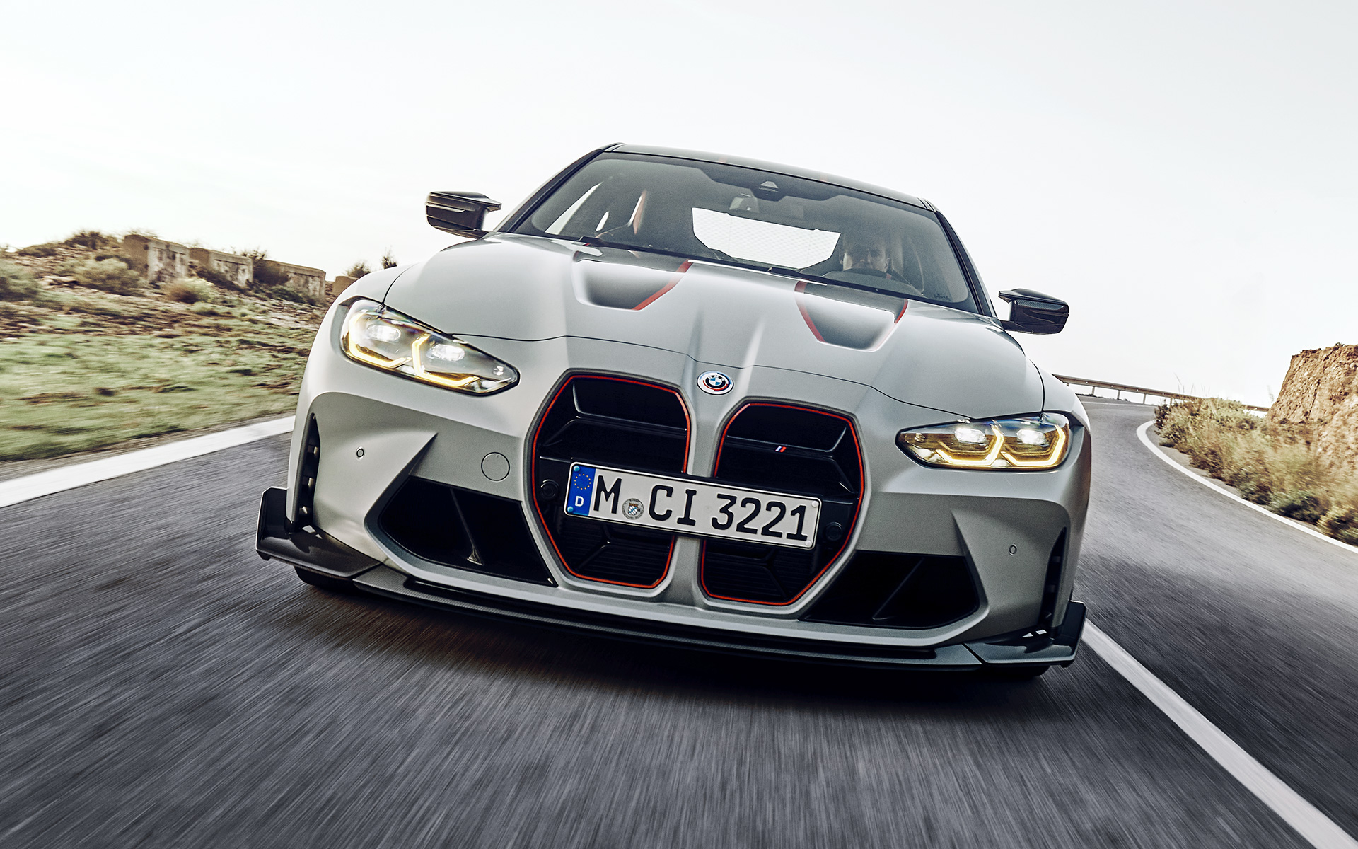 Решетка радиатора черного цвета с фирменным красным покрытием BMW M4 CSL G82 BMW M4 CSL G82 в цвете BMW Individual Frozen Brooklyn Grey металлик, радиаторная решетка черного цвета с фирменным красным покрытием, вид спереди в движении на улице.