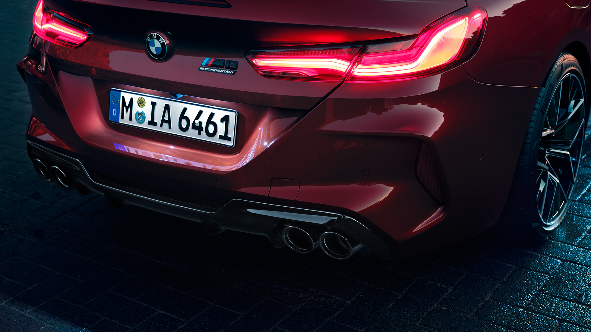 BMW M8 Competition Кабриолет, задняя часть. BMW M8 Competition Кабриолет в Motegi Red металлик, задняя часть со светодиодными задними фарами и значком M8 Competiton.