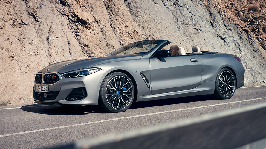 BMW M850i xDrive Cabrio G14 LCI Facelift 2022, BMW Individual Морозный Чистый Серый металлик, вид спереди в три четверти в движении на фоне скалы