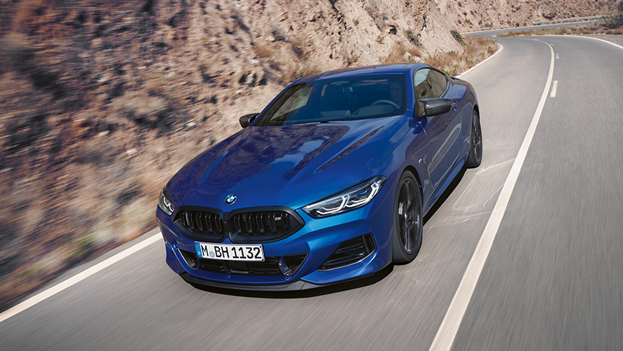 Вид спереди с поворотом в три четверти BMW M850i xDrive Coupé G15 LCI (рестайлинг 2022 года) BMW M850i xDrive Coupé G15 LCI (рестайлинг 2022 года), BMW Individual Синий Портимау металлик, вид спереди с поворотом в три четверти, в движении