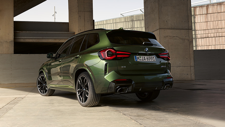 BMW X3 M G01 LCI Facelift 2021 в цвете Malachite Green металлик, вид сзади в три четверти на месте