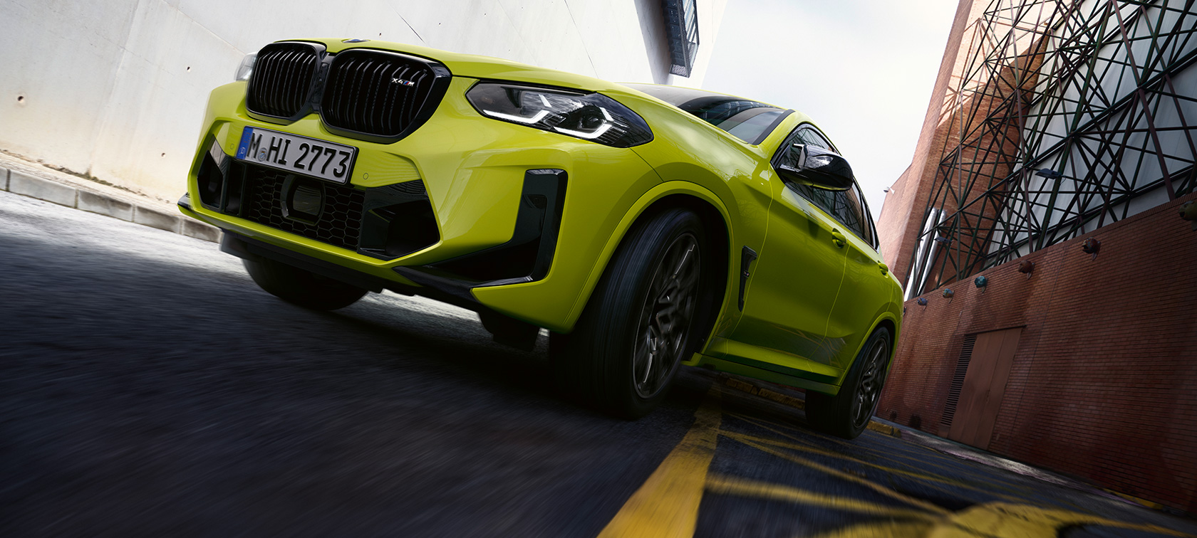 Вид спереди в три четверти с видом снизу BMW X4 M Competition F98 LCI 2021 BMW X4 M Competition F98 LCI Facelift 2021 в цвете Sao Paulo Yellow, вид спереди в три четверти с видом снизу проезжая через cектор домов
