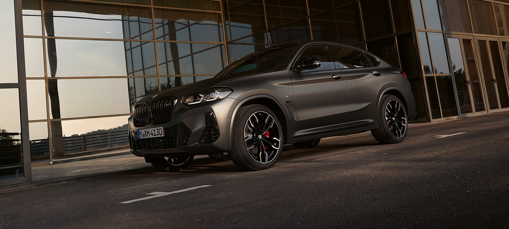 Вид спереди на три четверти BMW X4 M40i G02 LCI 2021 Facelift BMW X4 M40i G02 LCI 2021 Facelift, вид спереди в три четверти перед стеклянным фасадом