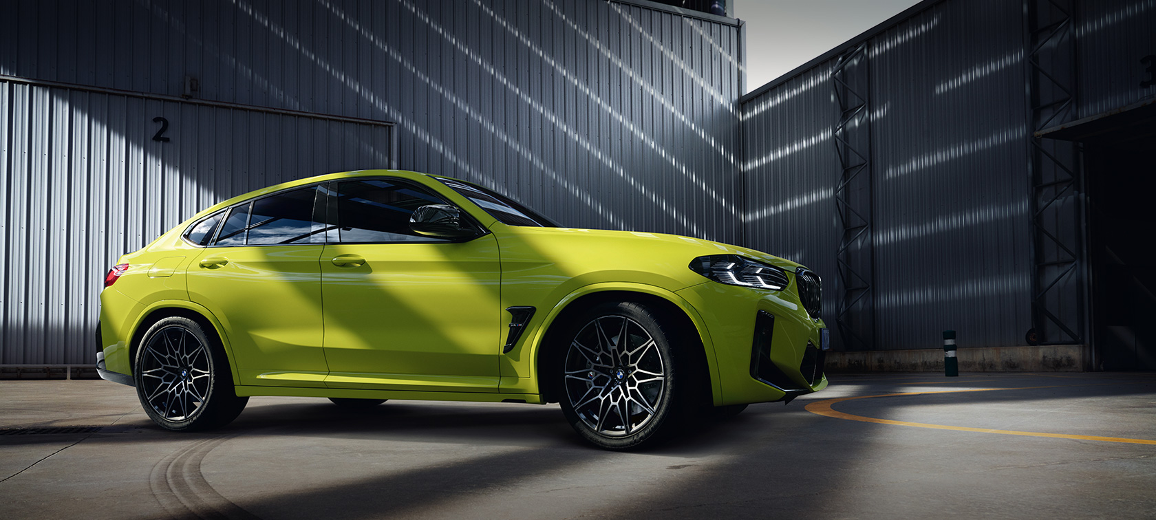 BMW X4 M Competition F98 LCI Facelift 2021 в цвете Sao Paulo Yellow, вид сбоку в холле