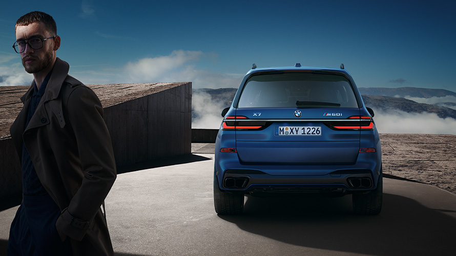 BMW X7 M60i xDrive G07 LCI окраска кузова морозный синий (Frozen Marina Bay Blue), вид сзади перед горным пейзажем, с моделью