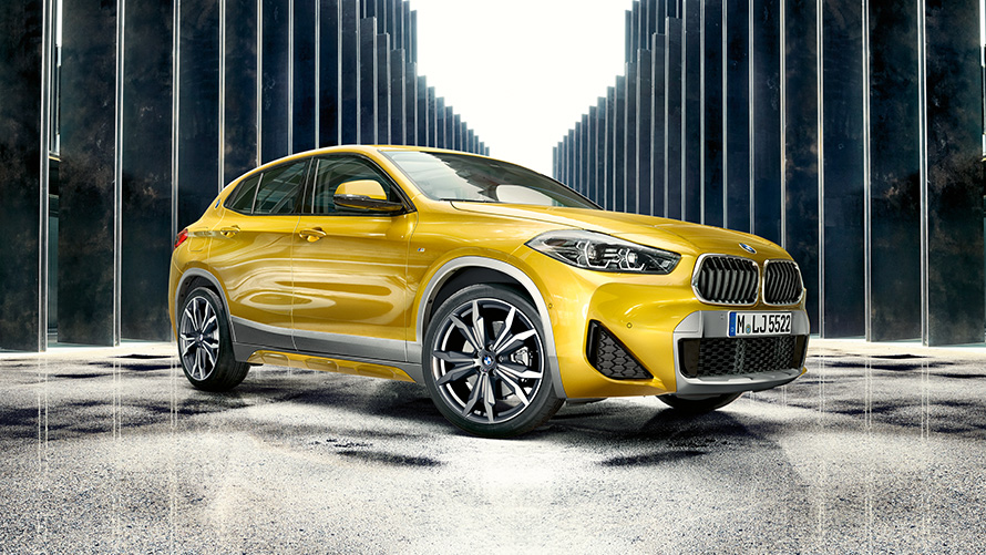 BMW X2 F39 "Серый Бруклин", вид сзади в три четверти с открытой дверью и двумя людьми BMW X2 F39 "Серый Бруклин", вид сзади в три четверти с открытой дверью и двумя людьми
