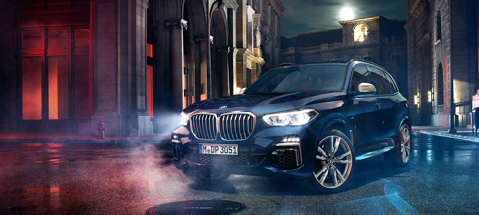 BMW X5 M50d на дороге BMW X5 M50d стоит на дороге на фоне ночного города