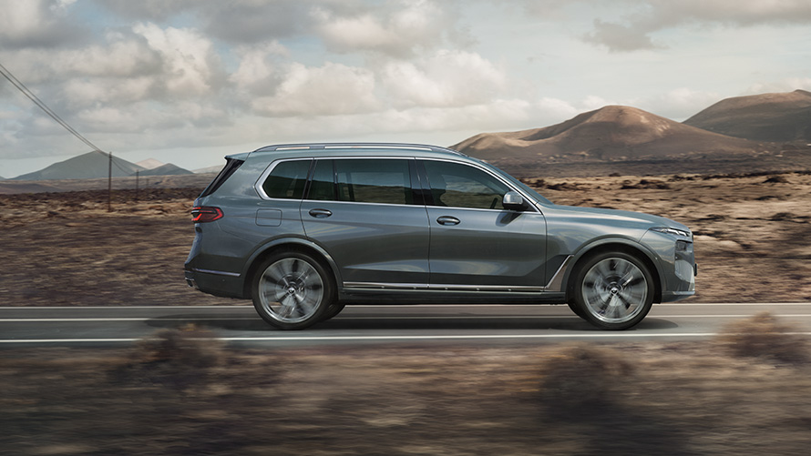 BMW X7 G07 LCI окраска кузова медно-серый металлик (Sparkling Copper Grey metallic), вид сбоку BMW X7 G07 LCI окраска кузова медно-серый металлик (Sparkling Copper Grey metallic), вид сбоку (в движении)