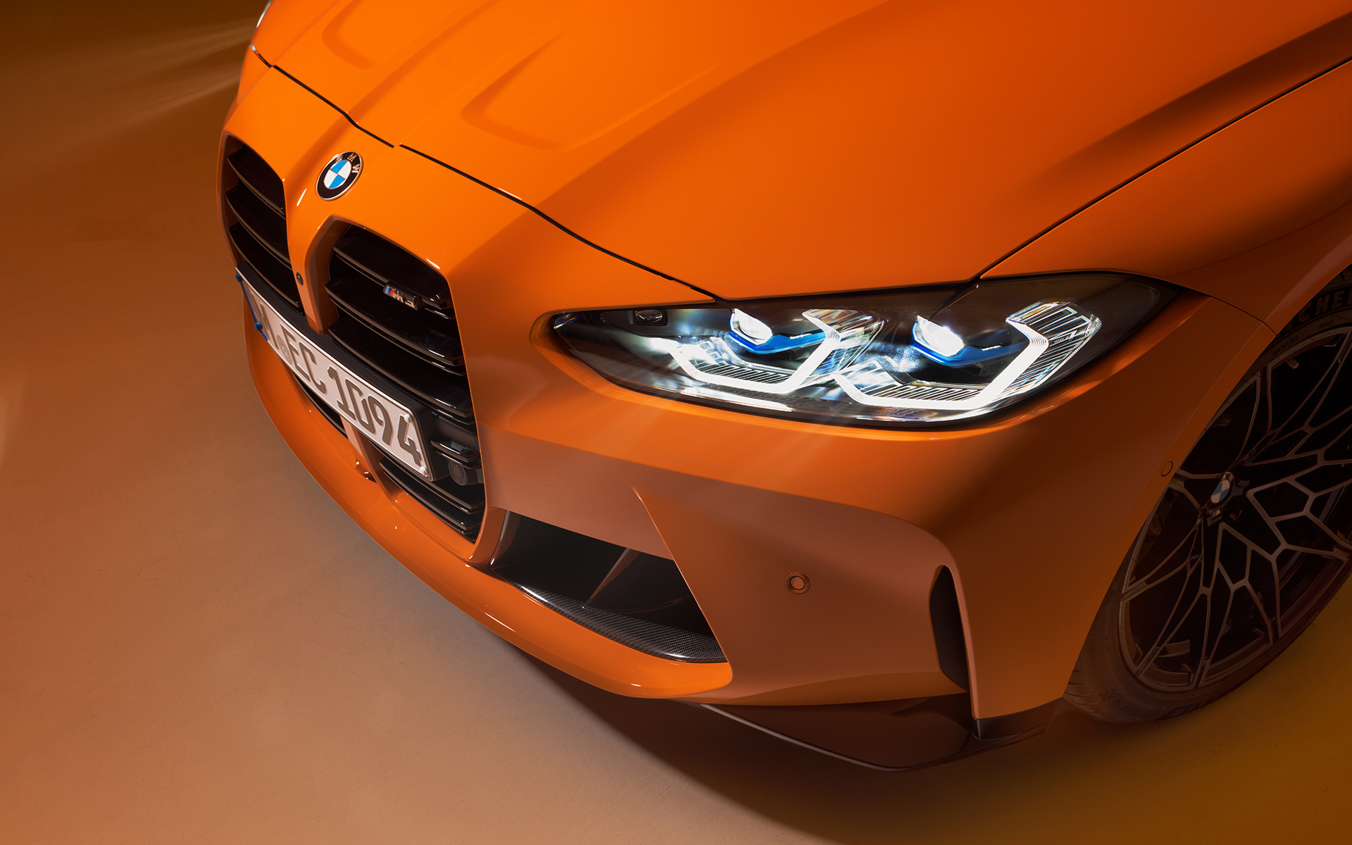 BMW M4 Competition Coupe G82 2021 BMW Individual Fire Orange, вид спереди в три четверти BMW M4 Competition Coupe G82 2021 BMW Individual Fire Orange, в статике, вид спереди в три четверти, крупный план в виде сверху