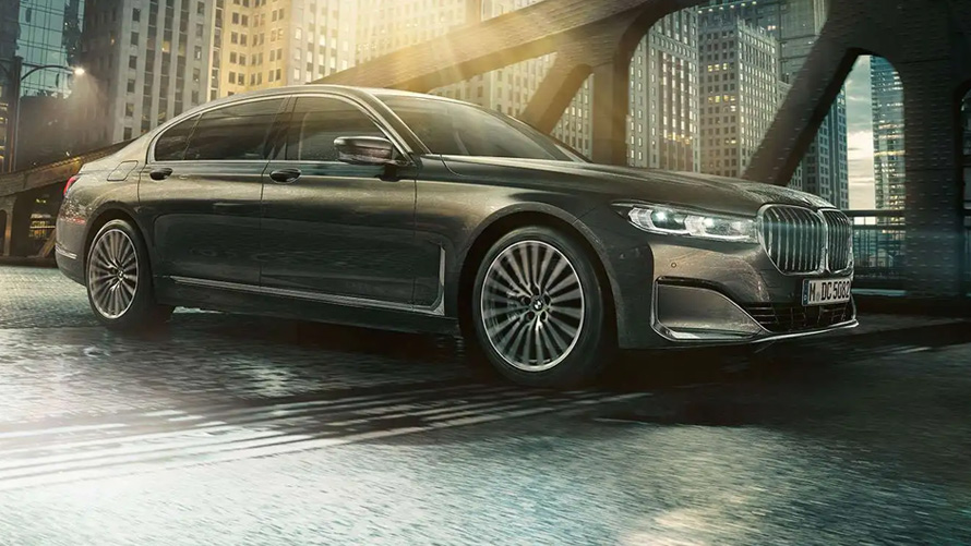 BMW M760Li xDrive G11 G12 2019 Frozen Dark Silver metallic, вид сбоку в три четверти в городе BMW M760Li xDrive G11 G12 2019 Frozen Dark Silver metallic, вид сбоку в три четверти в городе