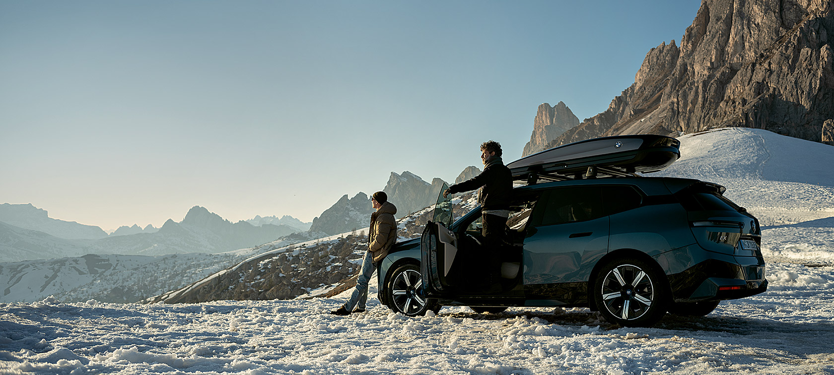 Оригинальные аксессуары и сервис BMW: осень/зима Мужчины и BMW iX на фоне снежного пейзажа